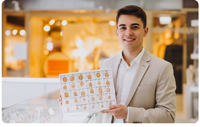 Jewelry inventory management example – jeweler showing gold pendants in a retail jewelry store